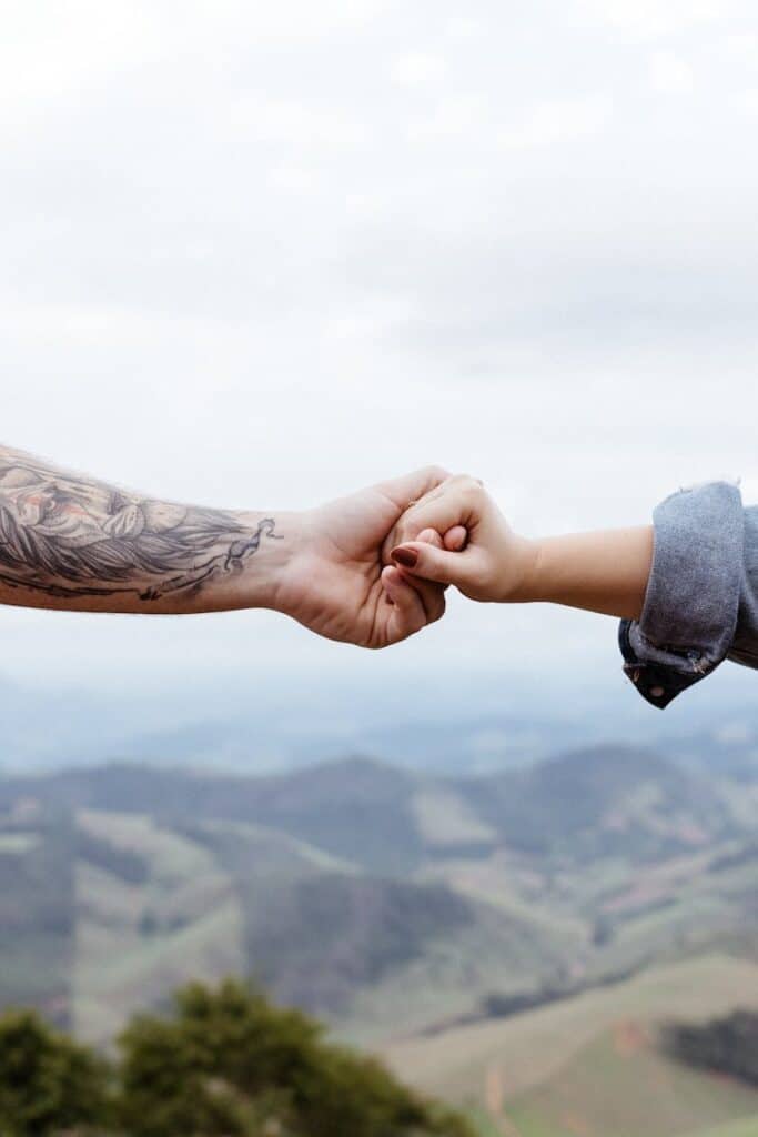Hands meeting against a mountainous backdrop symbolizing connection and togetherness.