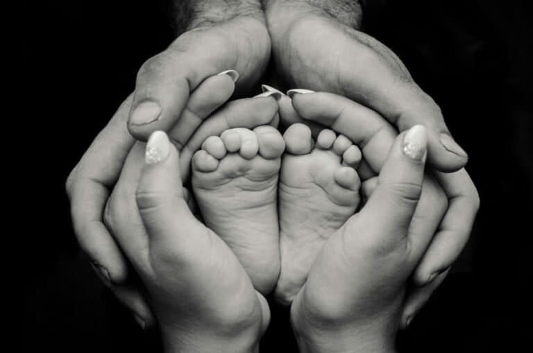 greyscale photography of human feet and hand