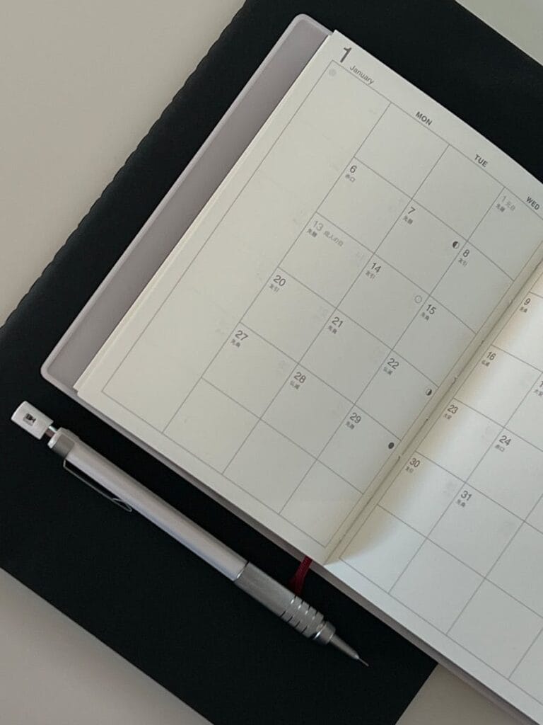 Close-up of an open monthly calendar with a pen, ideal for planning and time management concepts.