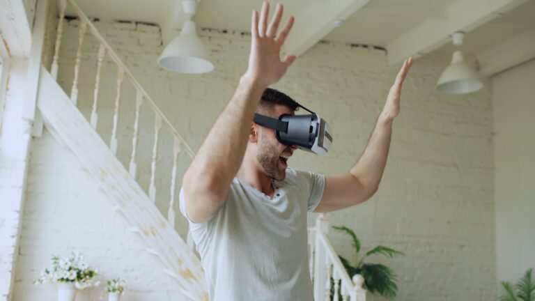 Man wearing vr headset with arms raised in excitement.
