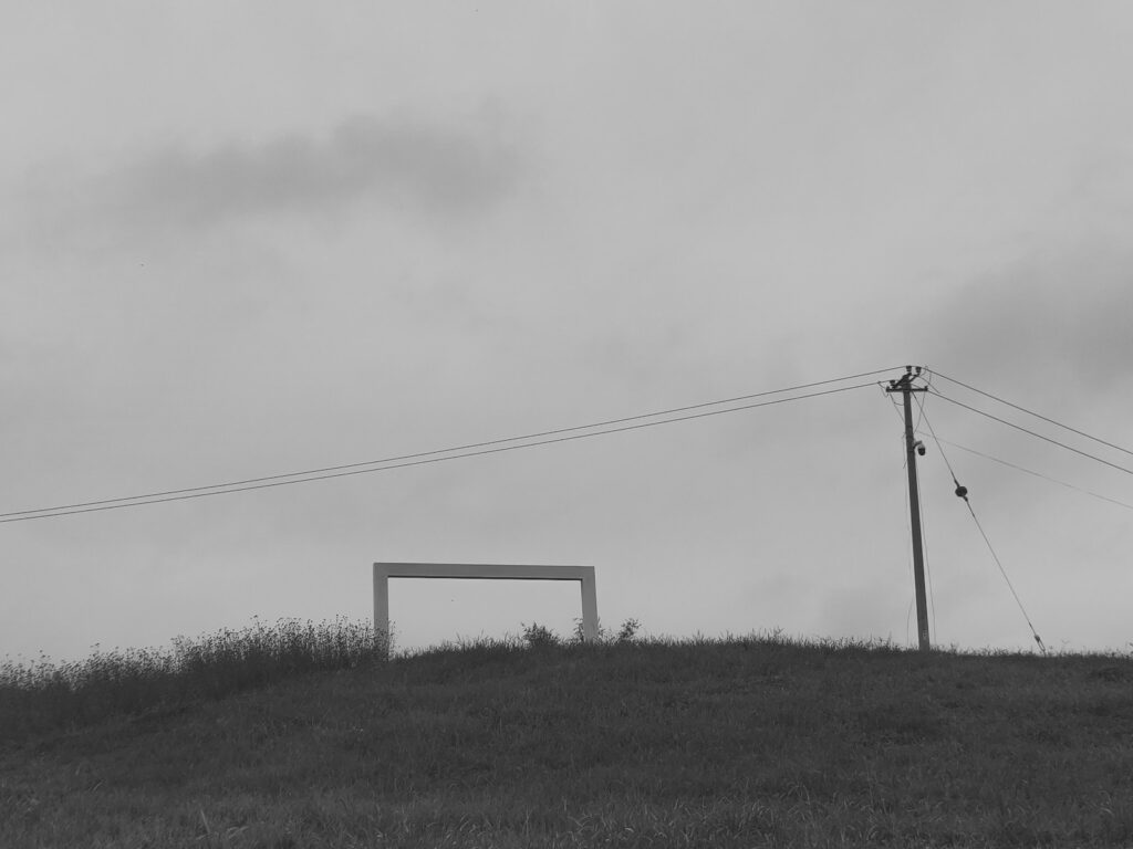 electric post on hill under cloudy sky