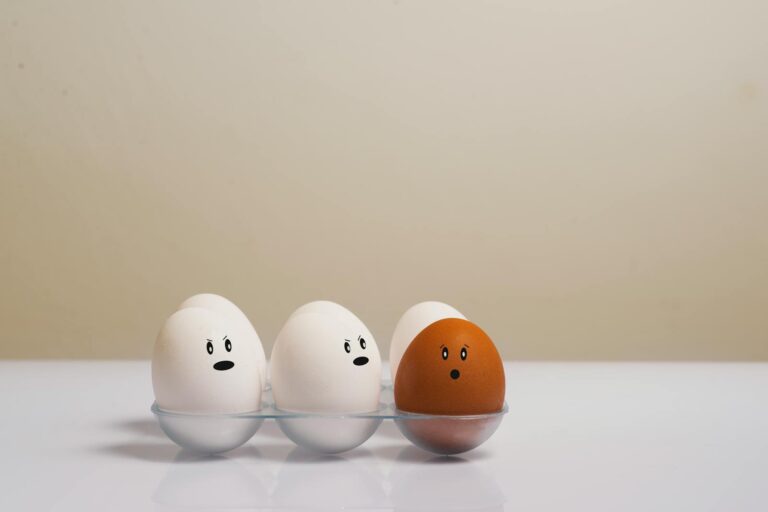 A creative depiction of eggs with facial expressions in a tray, symbolizing diversity.