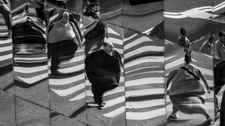 Abstract reflections of pedestrians on a Buenos Aires street in black and white.
