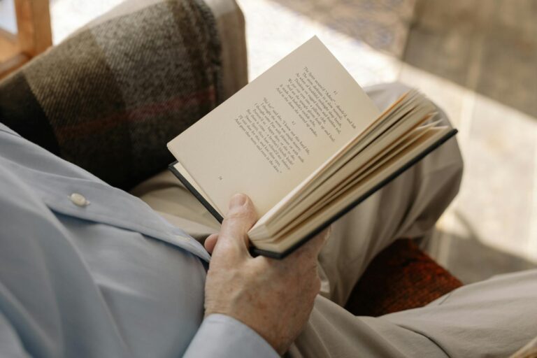 A cozy close-up of an adult reading indoors, capturing the serene moment.