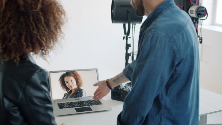 People looking at laptop screen with woman's portrait.
